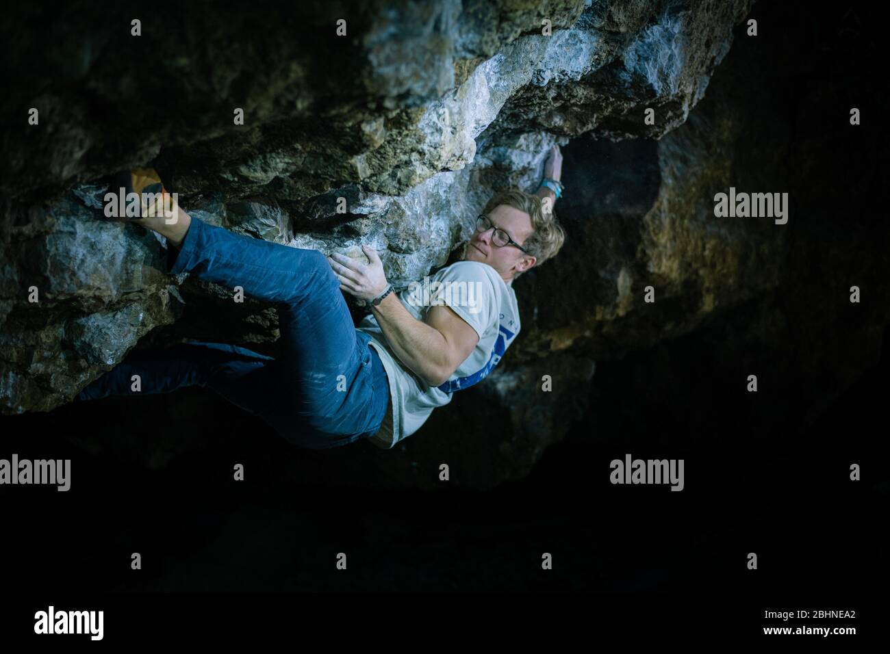 L'uomo sta facendo un masso nella grotta di Twardowski. Bouldering nella roccia. Grotta di Twardowski Foto Stock