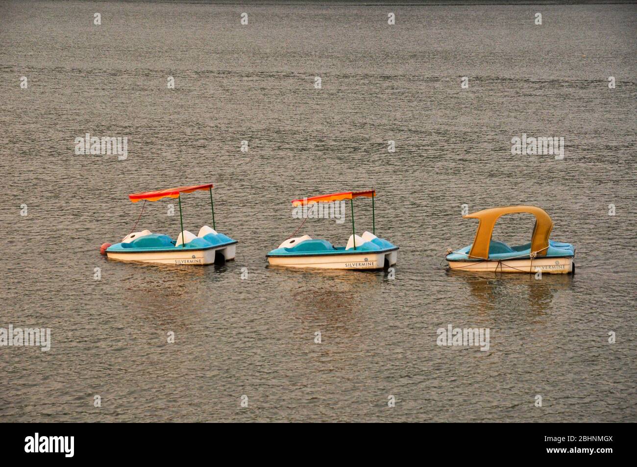 Tre pedalò sull'acqua ormeggiata senza persone, Lantau Island, Hong Kong Foto Stock