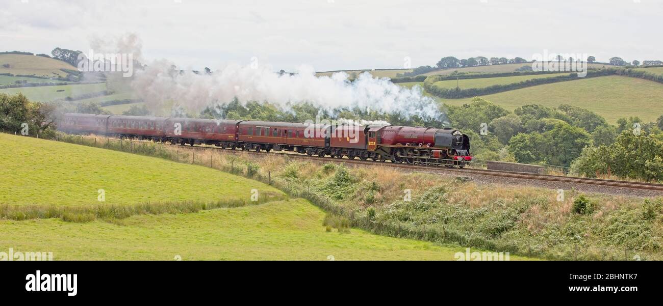 Locomotiva a vapore conservata 6233 'Duchess of Sutherland', che traeva un treno passeggeri attraverso la campagna del Devon, Inghilterra, Regno Unito. Foto Stock