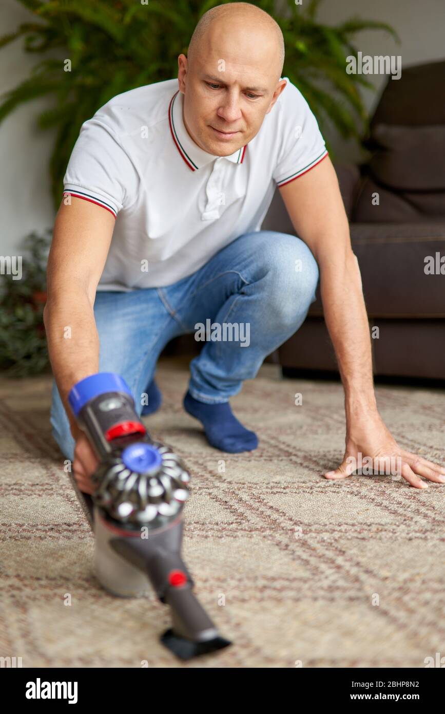 L'utente che utilizza il tappetino per la pulizia dell'aspirapolvere rimuove la polvere dal soggiorno Foto Stock