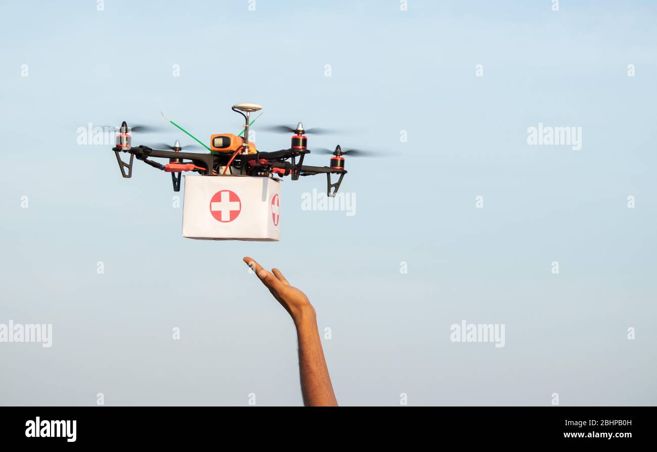 Mani che ricevono kit di assistenza medica o medicinali da drone o quadricottero durante il covid-19 o il blocco del coronavirus - logistica dell'industria medica per la droga Foto Stock