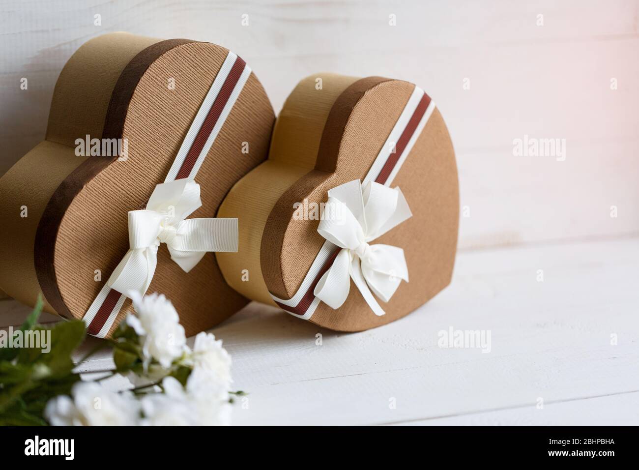Concetto di storie d'amore e per San Valentino. Due scatole regalo a forma di cuore su sfondo bianco. Foto Stock