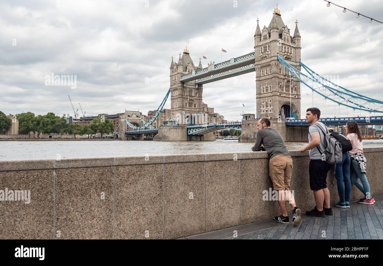 Turisti a Tower Bridge, Londra, Regno Unito. Un gruppo di famiglie che visita l'iconico monumento di Londra, il Tower Bridge sul Tamigi. Foto Stock