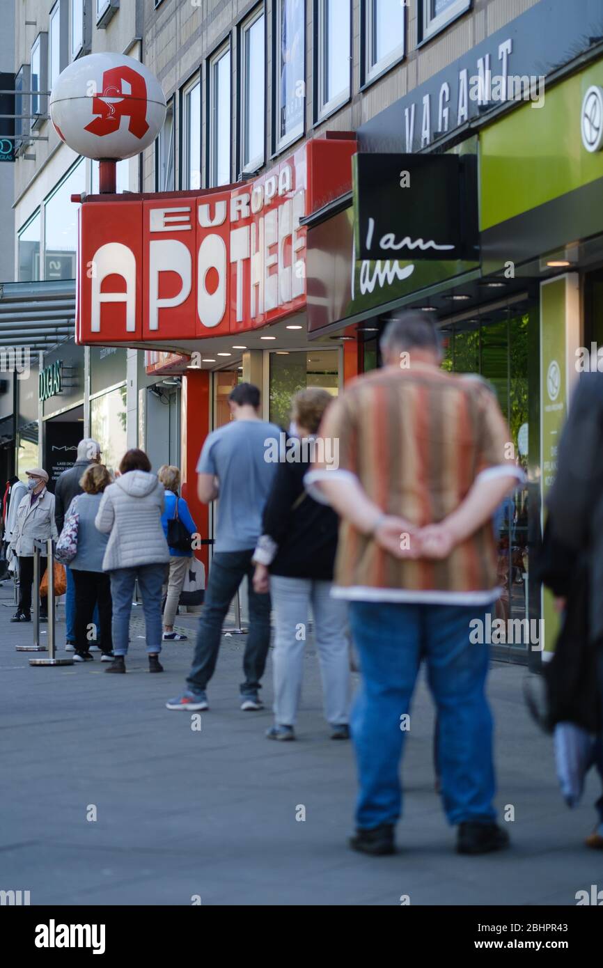 Hannover, Germania. 27 aprile 2020. I passanti si accodano davanti a una farmacia nel centro della città. Da lunedì, le maschere sono obbligatorie in bassa Sassonia per i trasporti pubblici e i negozi. Credit: OLE Spata/dpa/Alamy Live News Foto Stock