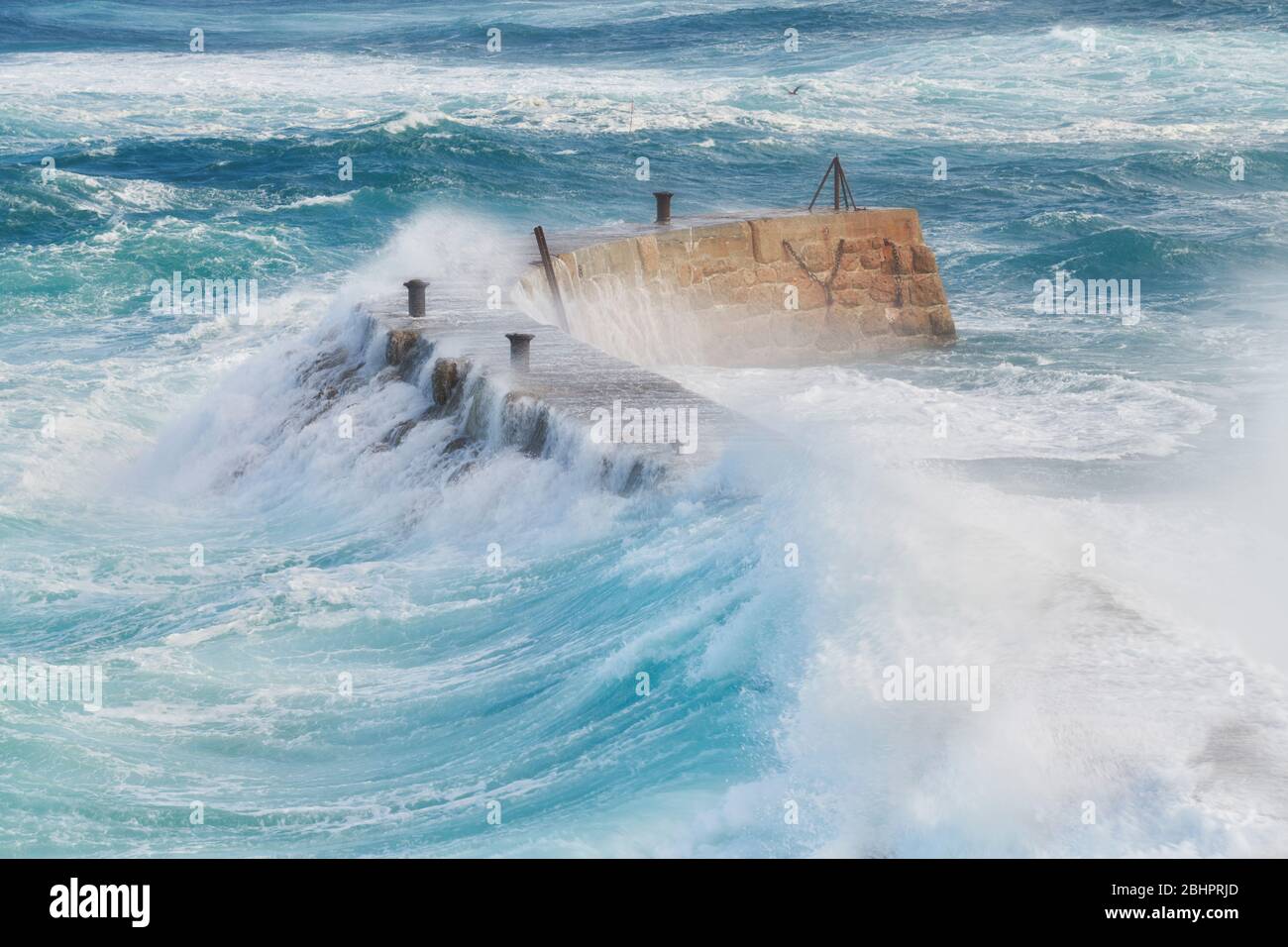Sennen Harbour frangiflutti, onde crash sopra il muro di mare durante Storm Lorenzo Foto Stock