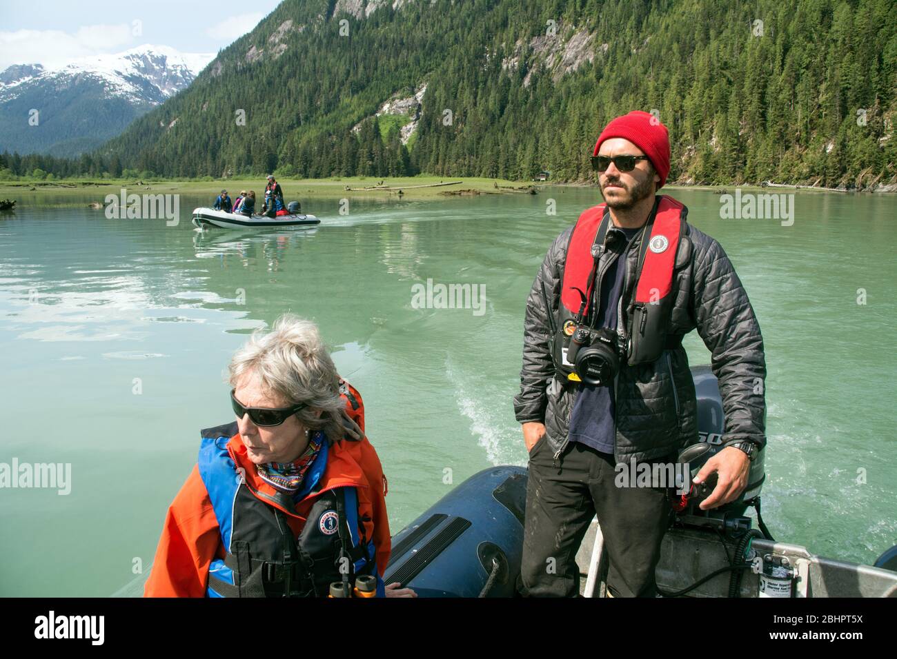 Una guida naturalistica ecoturismo che guida i turisti in barche zodiacali nell'Oceano Pacifico nella regione della foresta pluviale del Grande Orso, British Columbia, Canada. Foto Stock