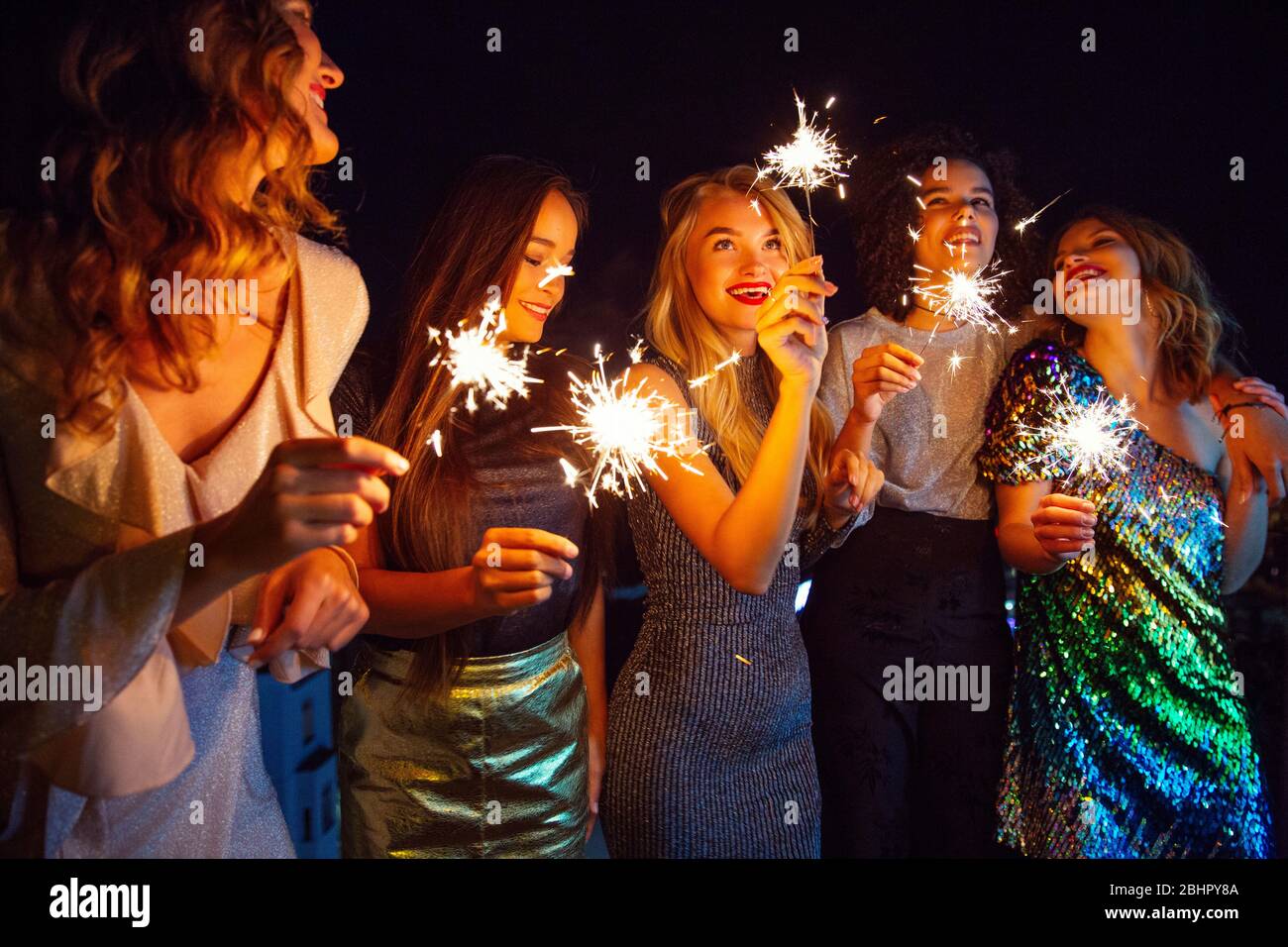 Cinque donne vestite per uscire per la sera fuori con i luccicanti. Foto Stock