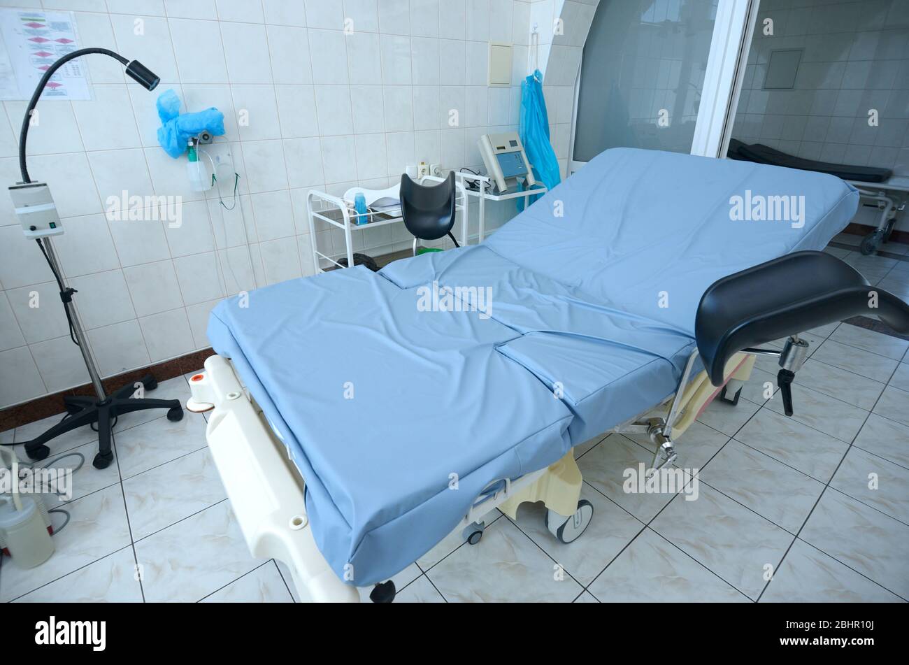 Letto ostetrico nella sala di consegna dell'ospedale di maternità, set di apparecchiature mediche Foto Stock