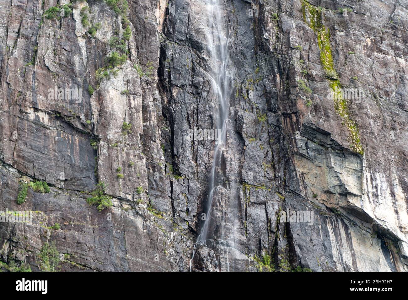 Crociera sul fiordo: Piccola cascata dalla montagna a Bergen, Norvegia Foto Stock