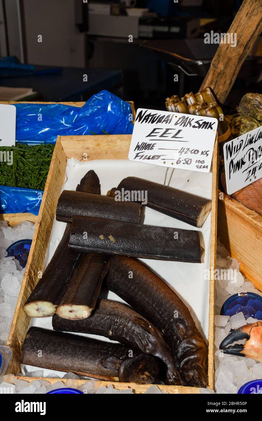 Un anguilla è un pesce lungo e sottile che assomiglia a un serpente. L'anguilla è la carne di questo pesce che viene mangiato come cibo. Pesce su ghiaccio al mercato del pesce Foto Stock