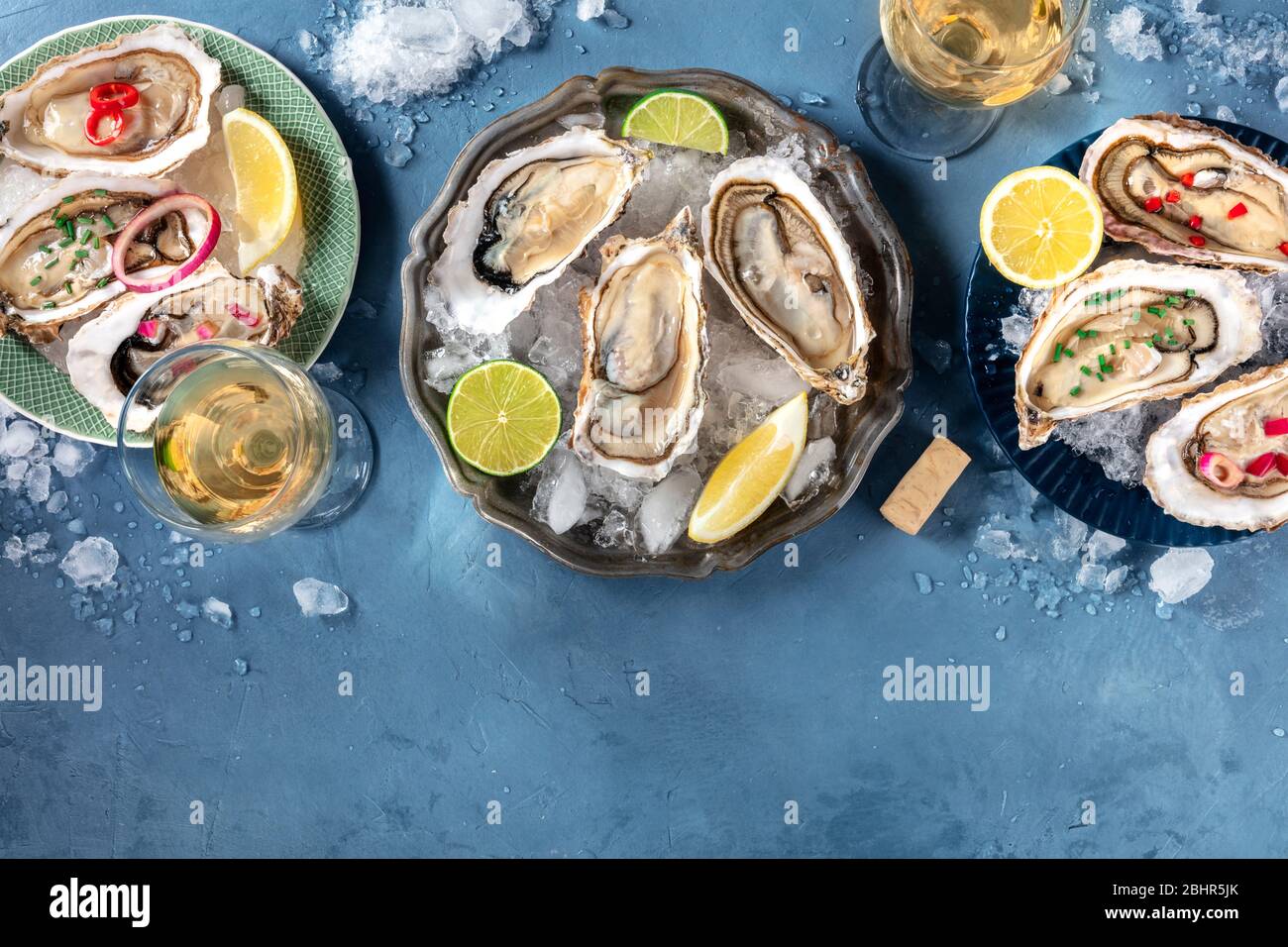 Ostriche con vari condimenti, farcite dall'alto con vino, limone e lime, pepe, cipolla, con un posto per il testo Foto Stock