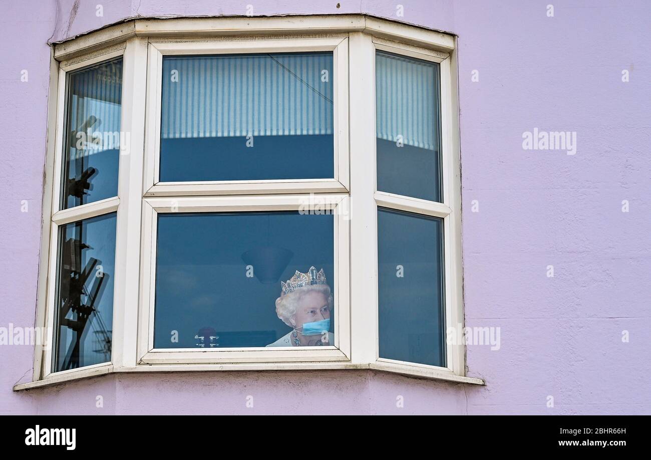 Brighton UK 27 Aprile 2020 - UN taglio della Regina che indossa una maschera si affaccia da una casa nella zona di Hannover di Brighton, mentre le restrizioni di blocco continuano durante la crisi pandemica Coronavirus COVID-19 . Credit: Simon Dack / Alamy Live News Foto Stock