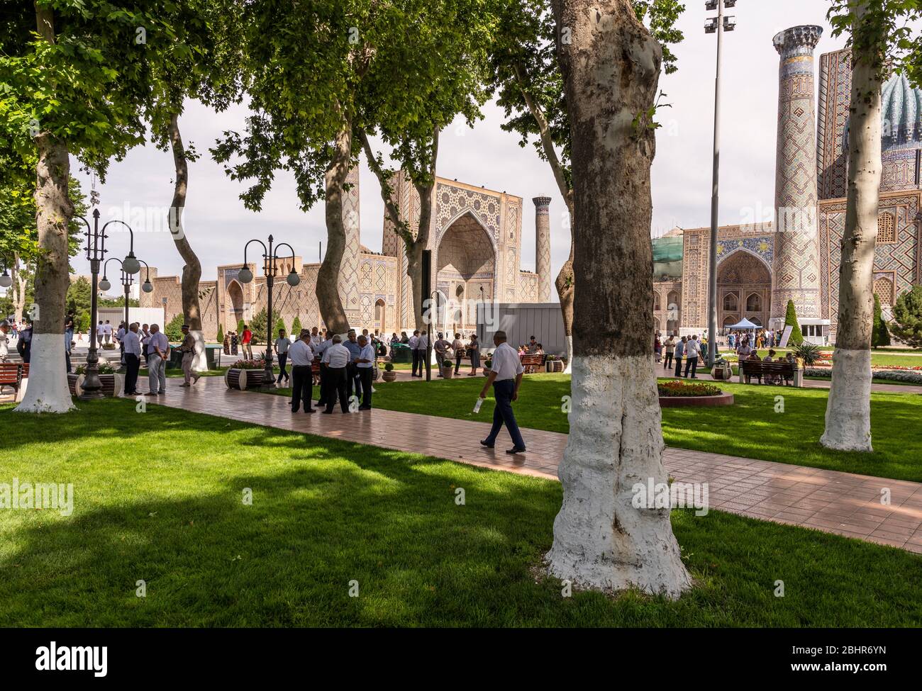 Samarqand, Uzbekistan - 9 giugno 2019: Piazza con persone, alberi e persone nella madrasa nel centro di Samarqand in Uzbekistan. Foto Stock