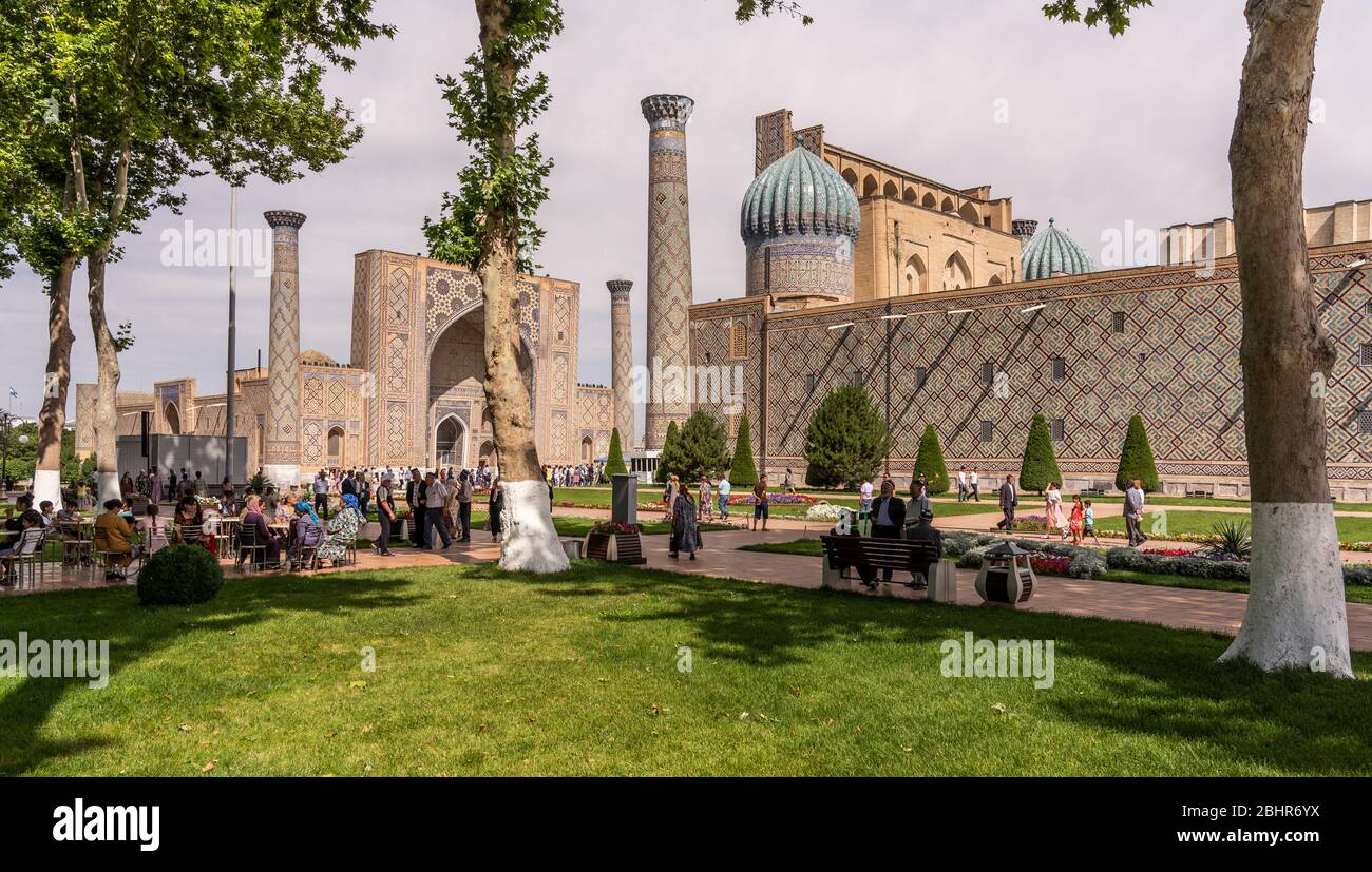 Samarqand, Uzbekistan - 9 giugno 2019: Piazza con persone, alberi e persone nella madrasa nel centro di Samarqand in Uzbekistan. Foto Stock