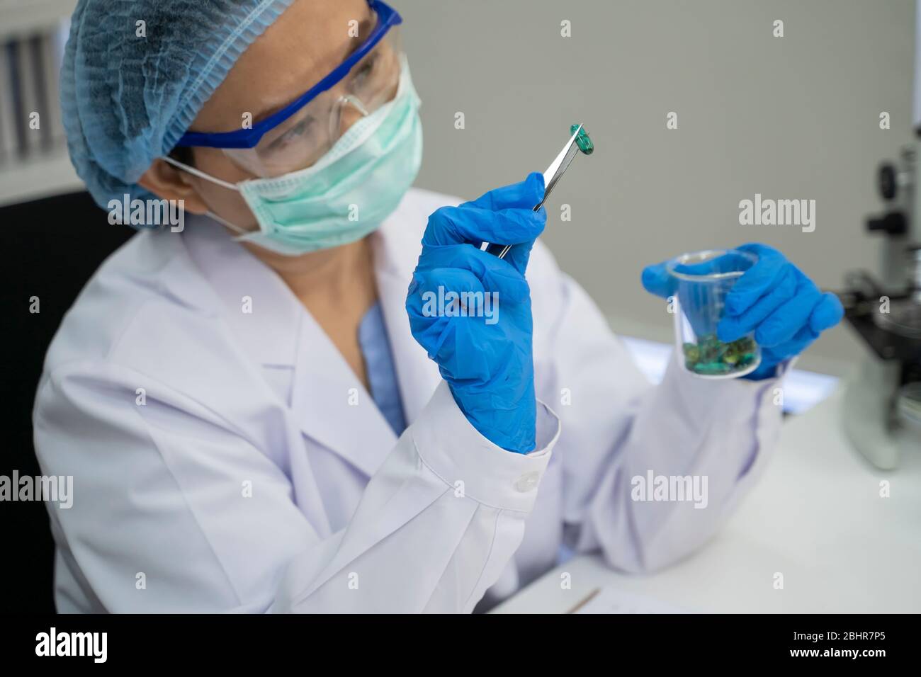 Il medico sta ispezionando il seme prodotto della medicina. Foto Stock