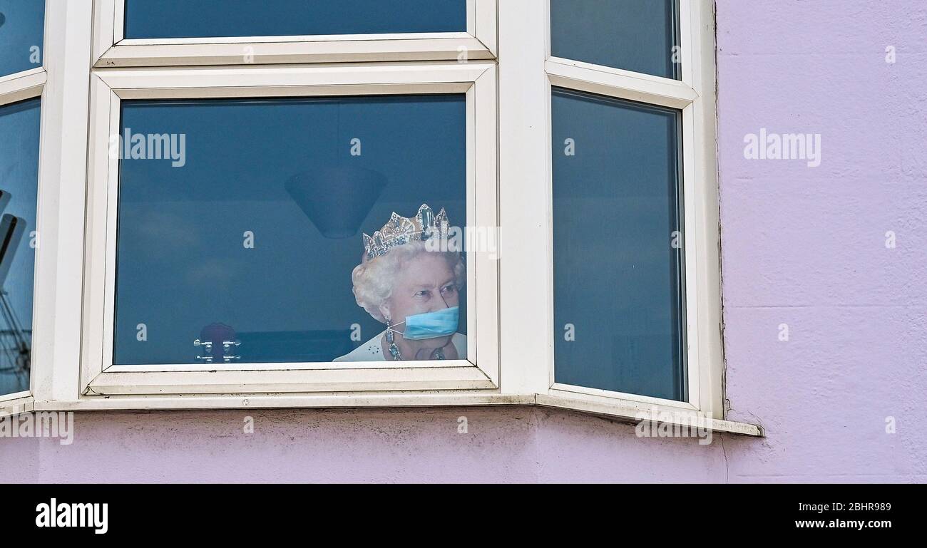 Brighton UK 27 Aprile 2020 - UN taglio della Regina che indossa una maschera si affaccia da una casa nella zona di Hannover di Brighton, mentre le restrizioni di blocco continuano durante la crisi pandemica Coronavirus COVID-19 . Credit: Simon Dack / Alamy Live News Foto Stock