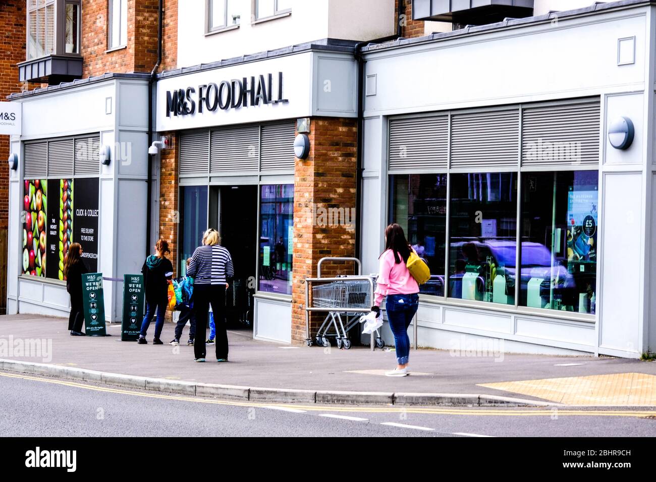 Gli acquirenti che fanno la coda fuori DA UNA sala alimentare di Marks and Spencer a Londra del sud, osservando le linee guida di blocco governative sulle distanze sociali Foto Stock