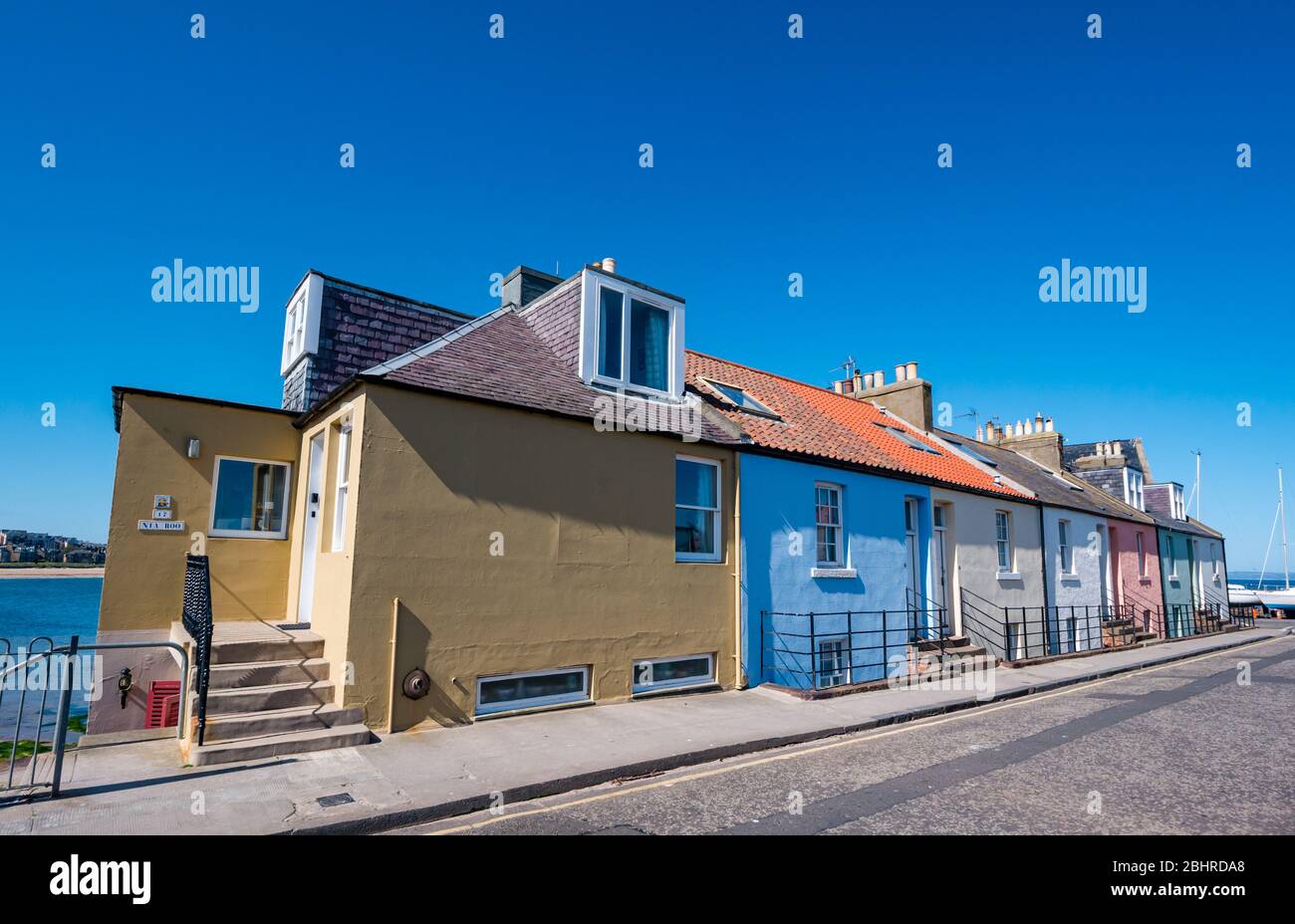 Colorati cottage sul mare dipinti in colori pastello con un cielo blu brillante, North Berwick, East Lothian, Scozia, Regno Unito Foto Stock