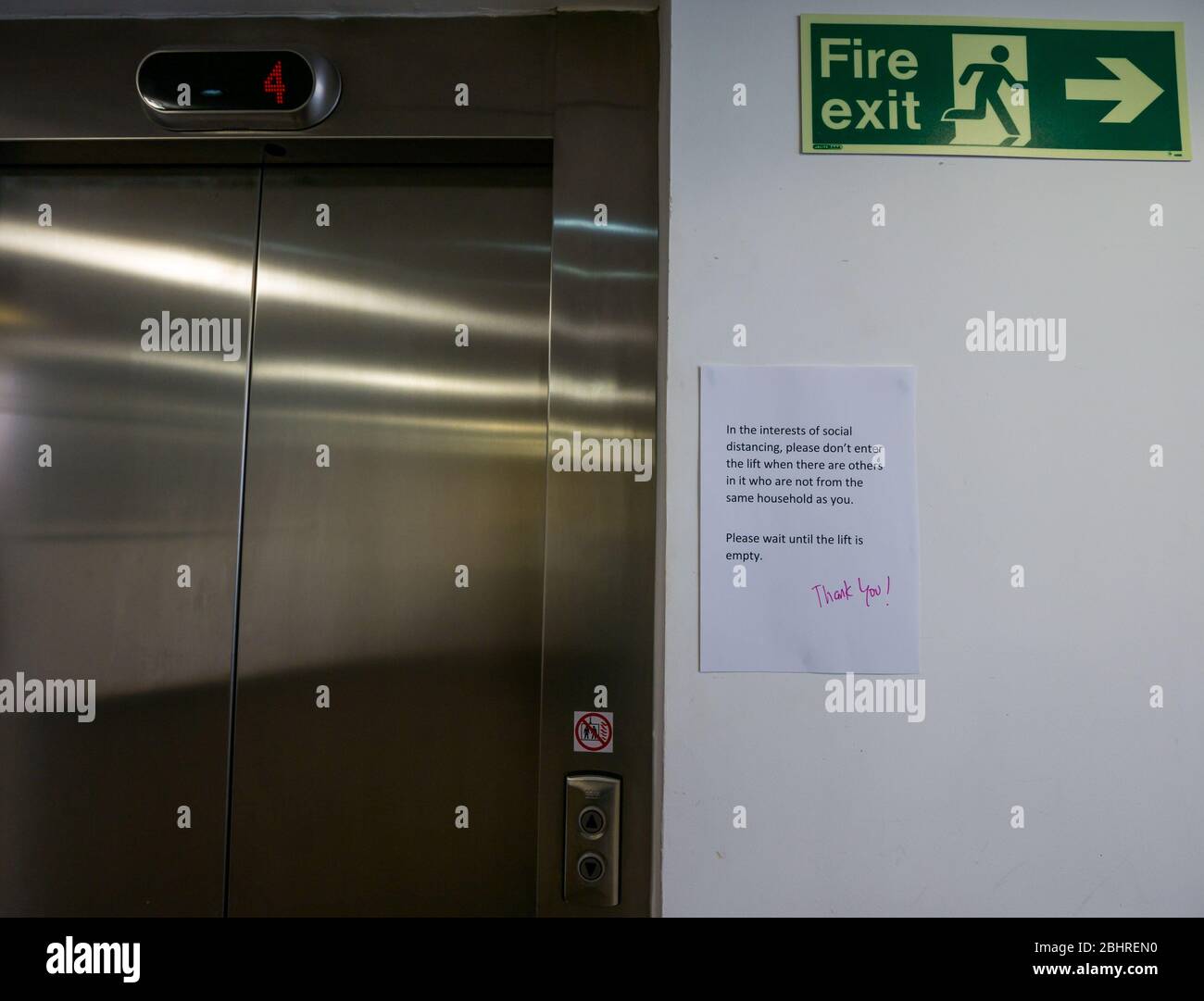 Avviso circa le distanze sociali sulla porta ascensore in blocco di appartamenti, Edimburgo, Scozia, Regno Unito Foto Stock