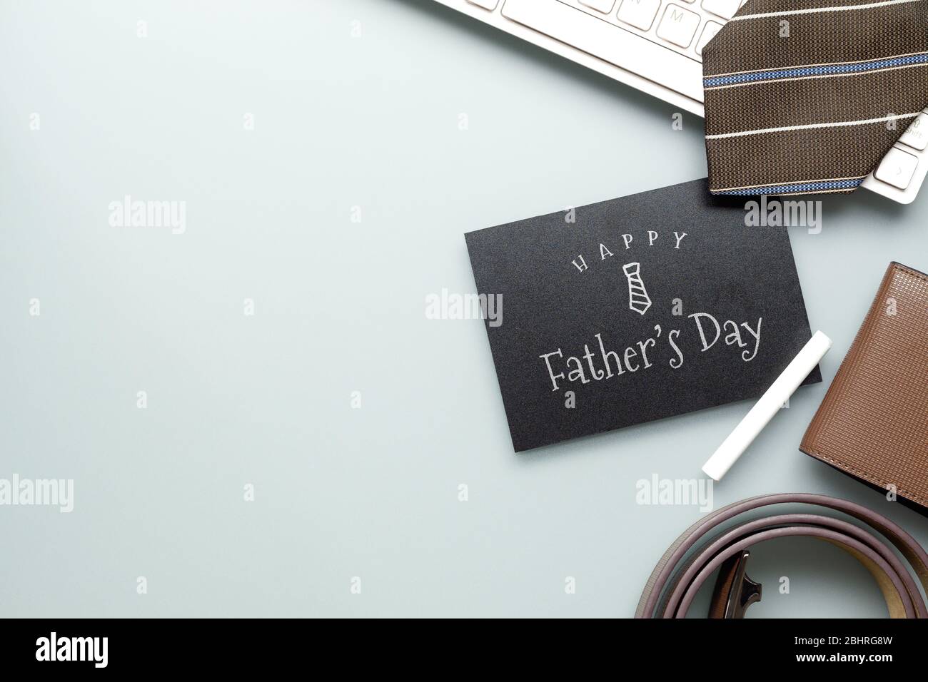 Messaggio del giorno di buon padre sulla lavagna. Composizione a base di piatti su scrivania con computer portatile, cravatta e accessori per uomo. Foto Stock