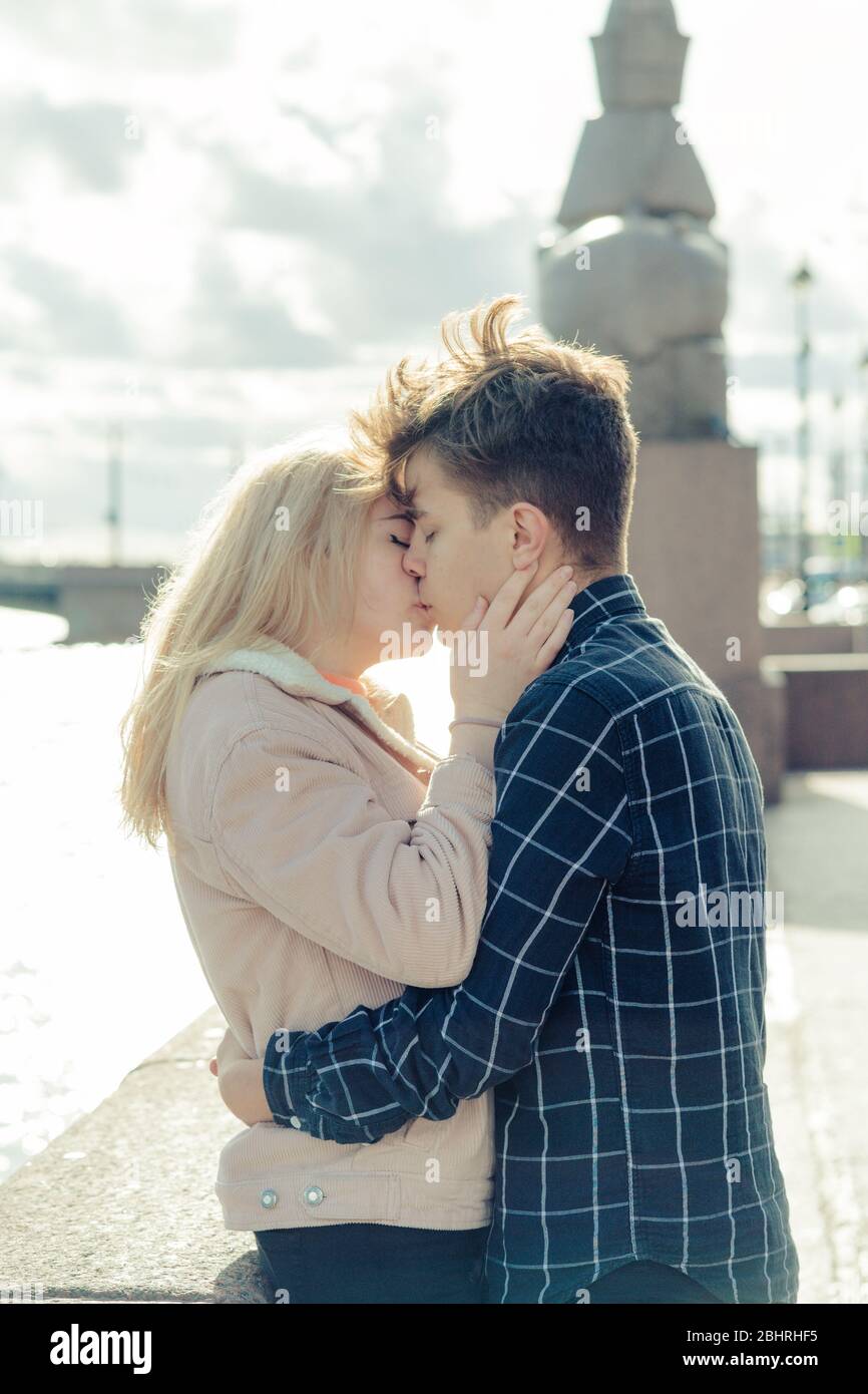 Il ragazzo guarda teneramente la ragazza e vuole baciarsi. Una giovane coppia si sta abbracciando. Il concetto di amore adolescente e primo bacio, sentimenti sinceri dell'uomo Foto Stock