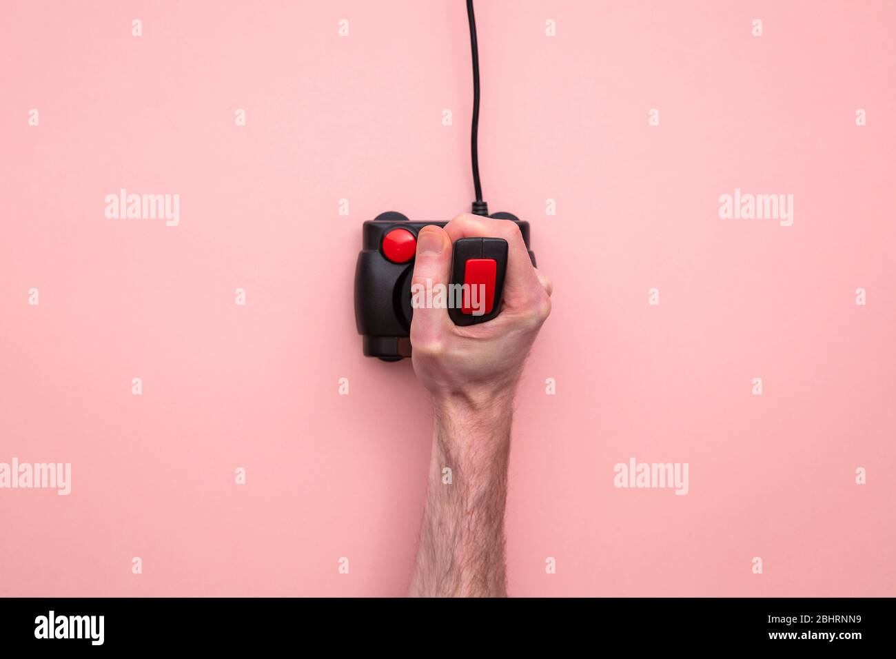 Mano maschile utilizzando il controller joystick per videogiochi retrò. Vista dall'alto Foto Stock