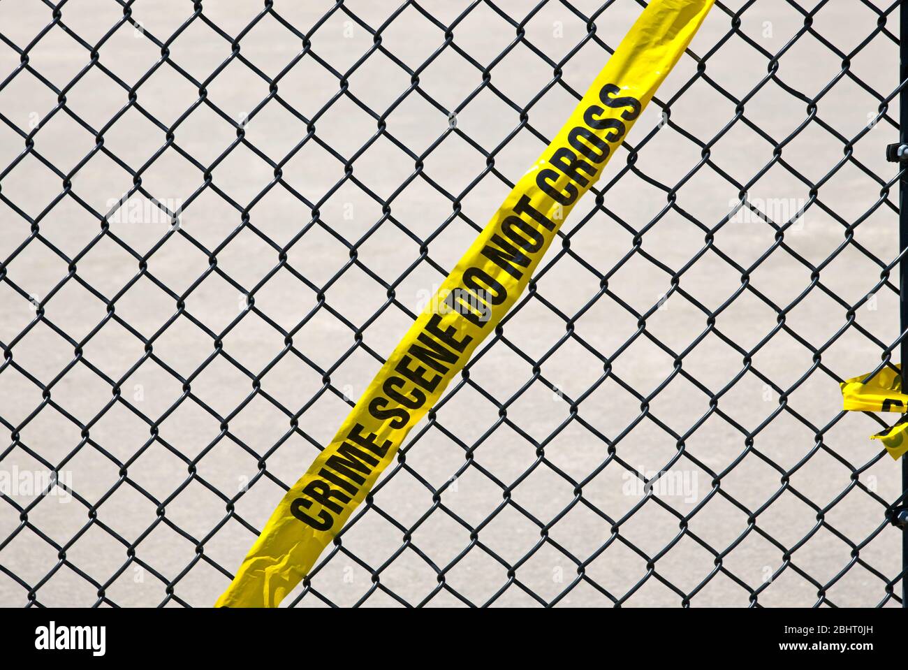 Nastro giallo da crimine appeso su una fence di Liink della catena nera Foto Stock