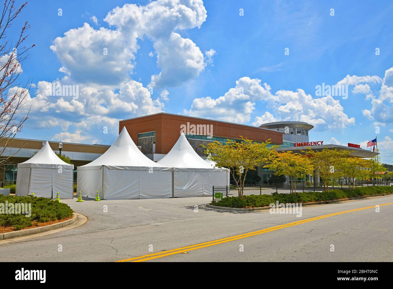 Centro medico con tende allestite all'esterno della sala di emergenza ingresso per lo screening di persone con sintomi del romanzo Coronavirus lontano da altri pazienti Foto Stock