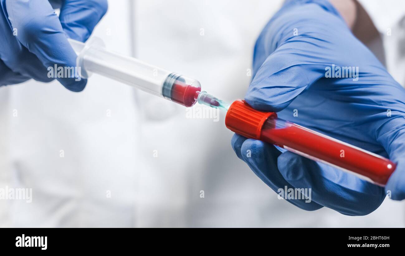 Il medico che traina il sangue nella siringa in laboratorio Foto Stock