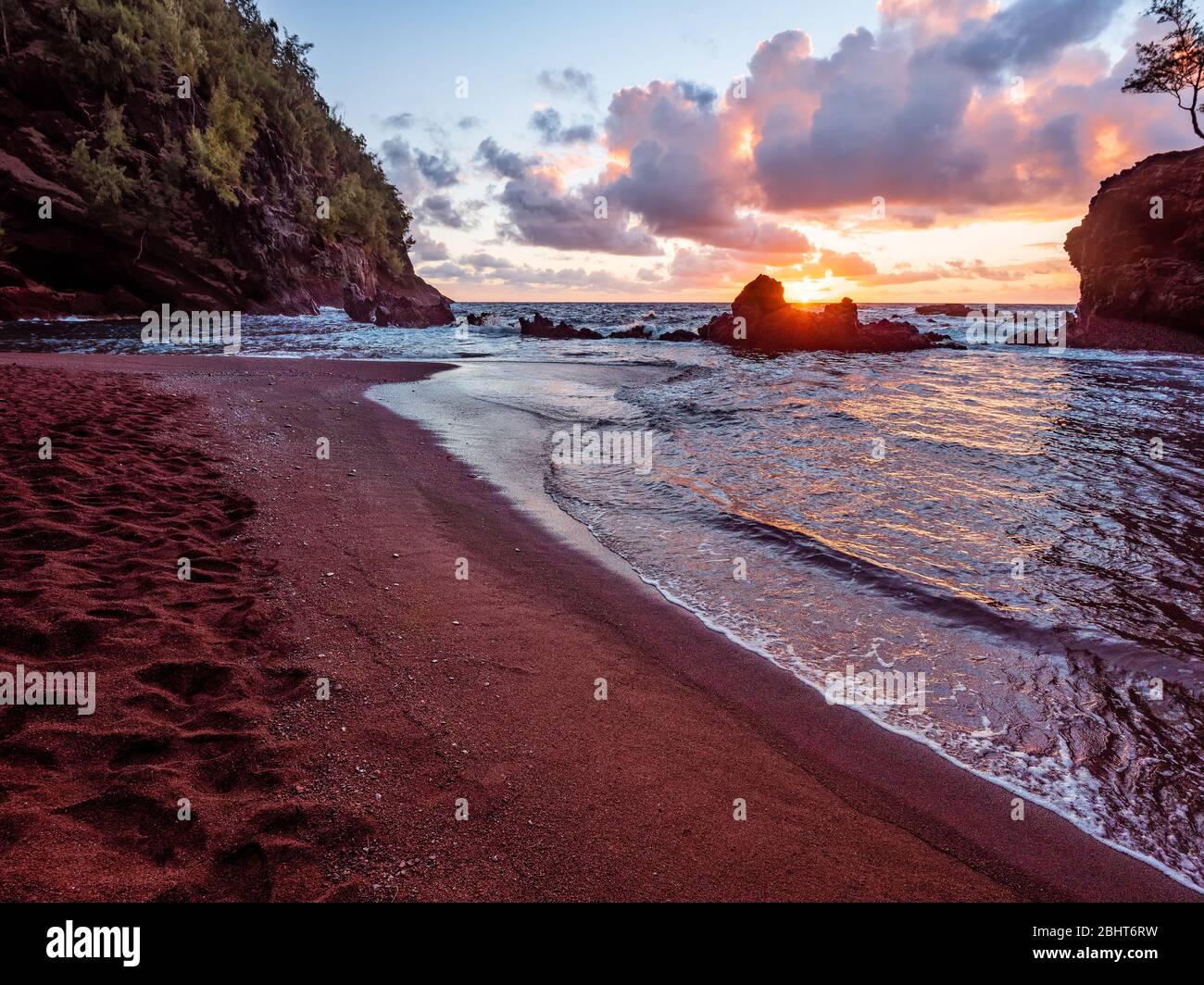 Sole che sorge sulla spiaggia di Red Sand (Kaihalulu Beach) a Maui. Foto Stock