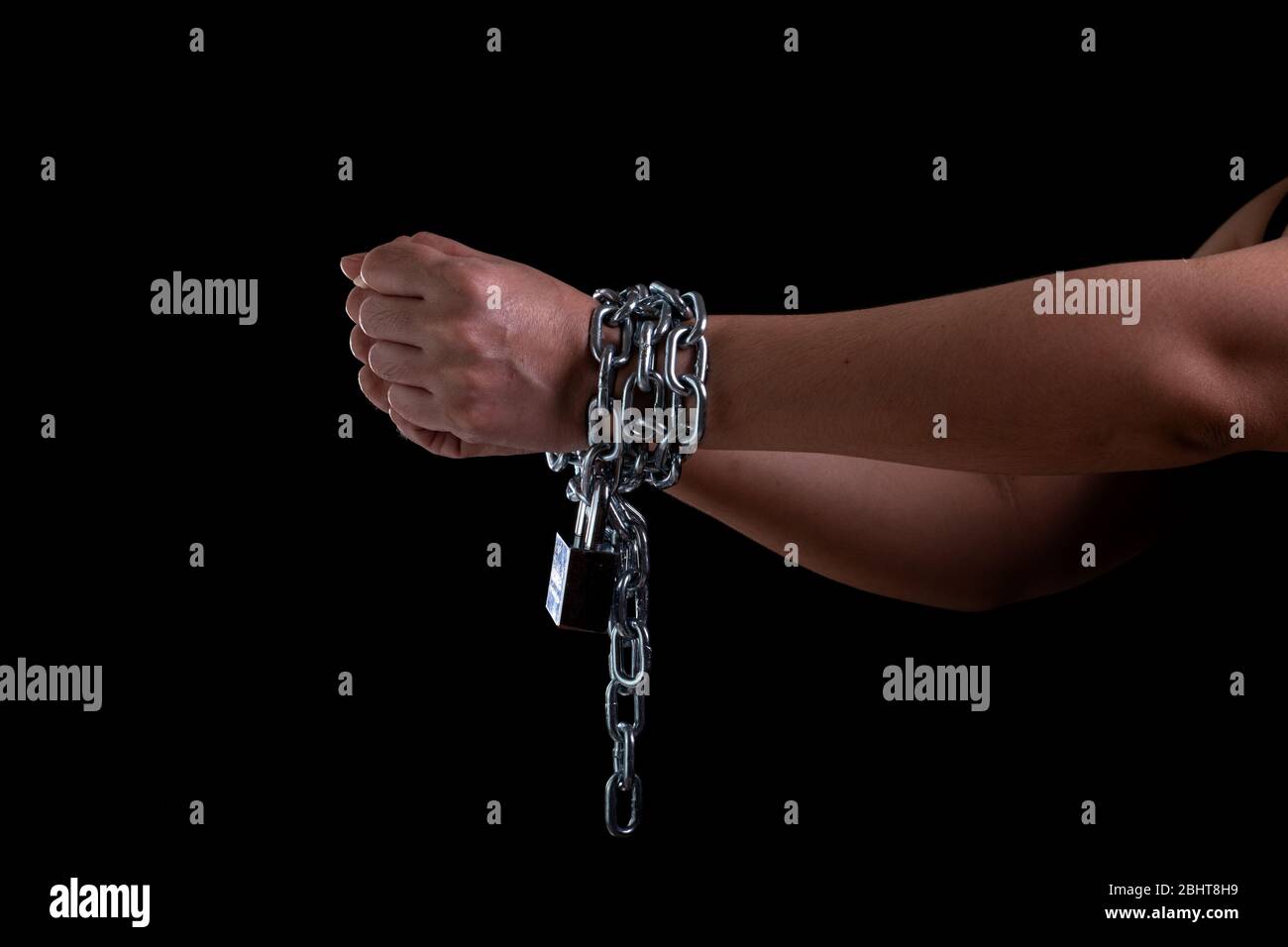 Mano della donna legata con catena d'acciaio e bloccare al fondo nero, violazioni dei diritti umani e il concetto di Giornata internazionale delle donne, donne vista frontale Foto Stock