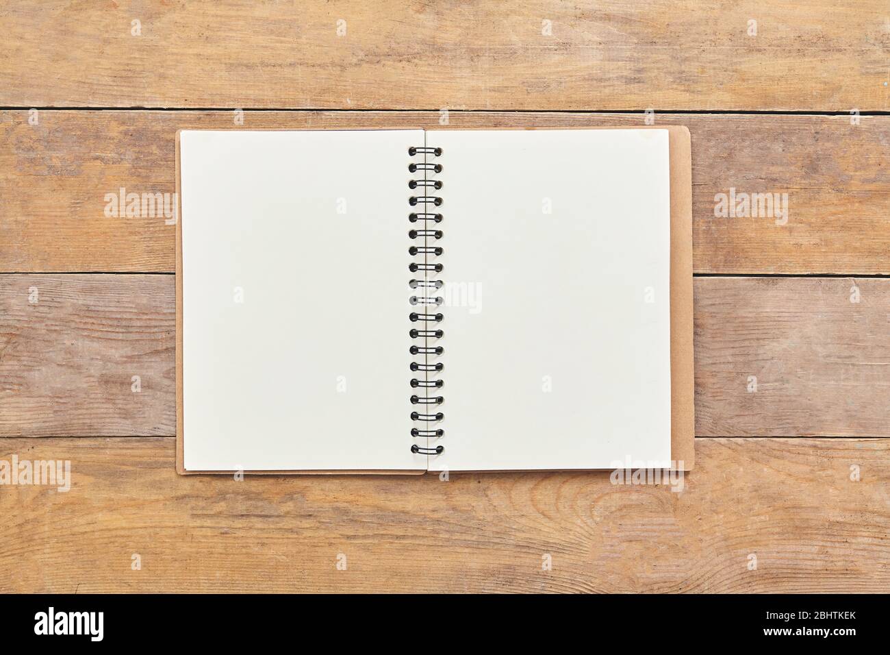 Blocco note o notebook con sfondo di tavola in legno marrone. Vista dall'alto. Foto Stock