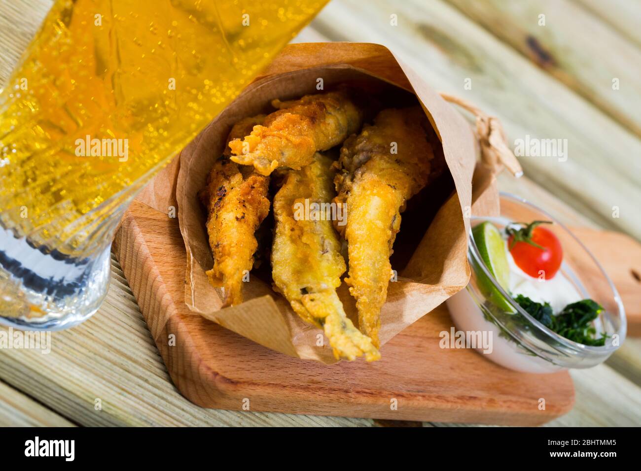 Pesce - patatine fritti in pastella di acciughe con la classica salsa di formaggio cremosa e verdi Foto Stock