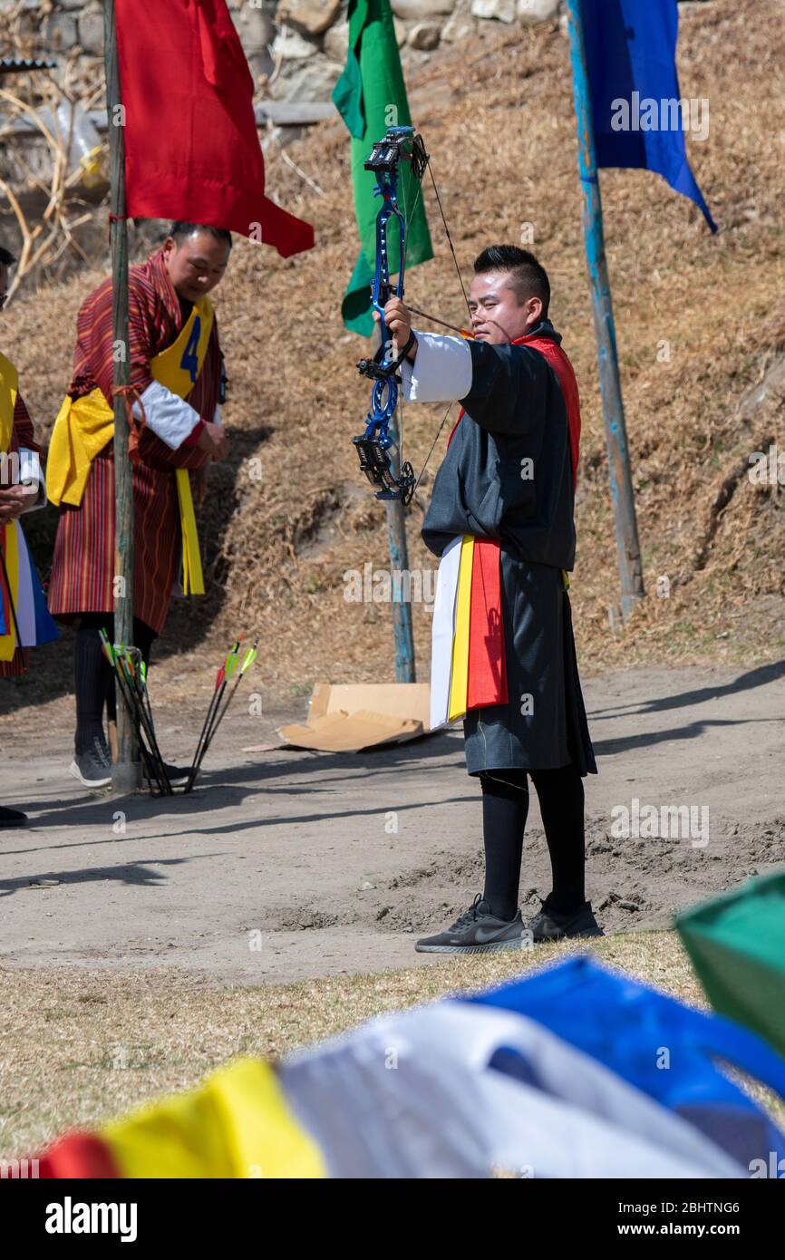 Bhutan, Paro. Concorso di tiro con l'arco, Bhutan's National sport. Archer in abbigliamento tradizionale. Foto Stock