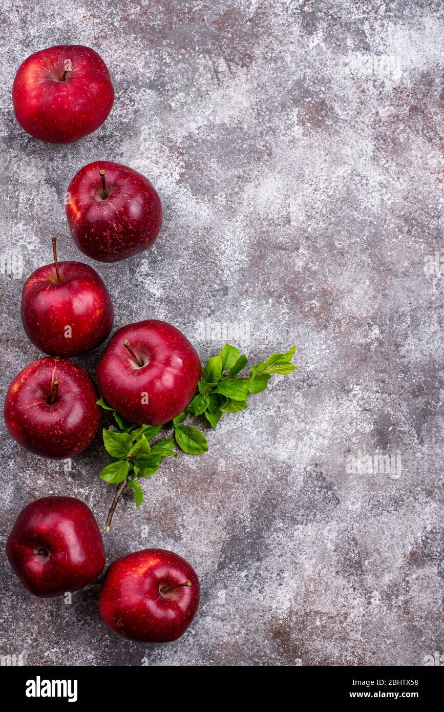Mele fresche rosse mature su sfondo grigio Foto Stock