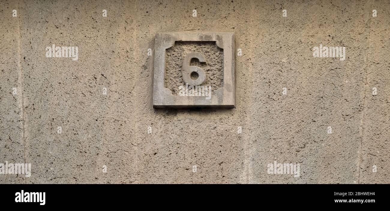 6, numero sei, numero decorativo su superficie grigia. Foto Stock