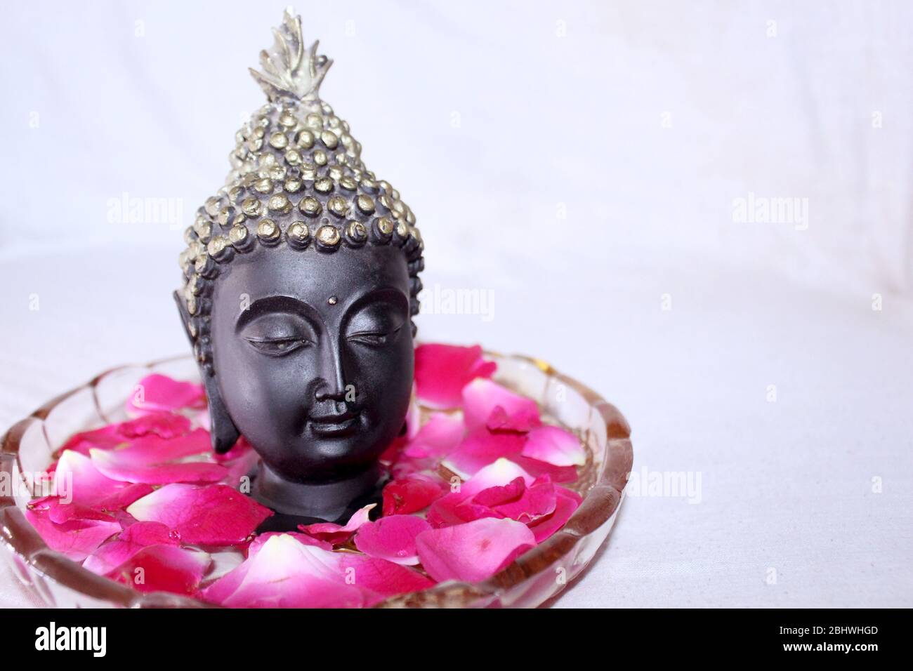 buddha dio faccia tra petali di rosa in ciotola, sfondo spa Foto stock -  Alamy