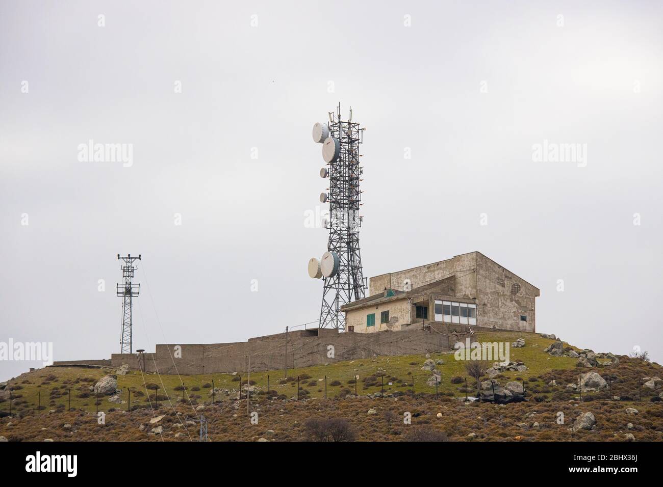 Una stazione base sul campo. Stazione di comunicazione del telefono cellulare. Su un lungo palo su una collina alta. Foto Stock
