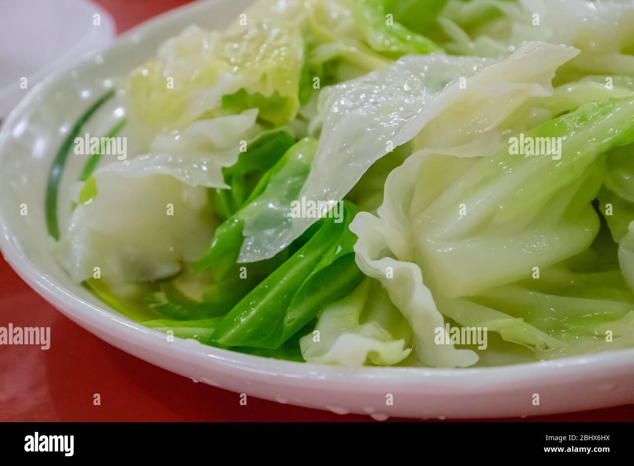 Il primo piano di delizioso fritto cavolo su piatto bianco al ristorante taiwanese. Foto Stock