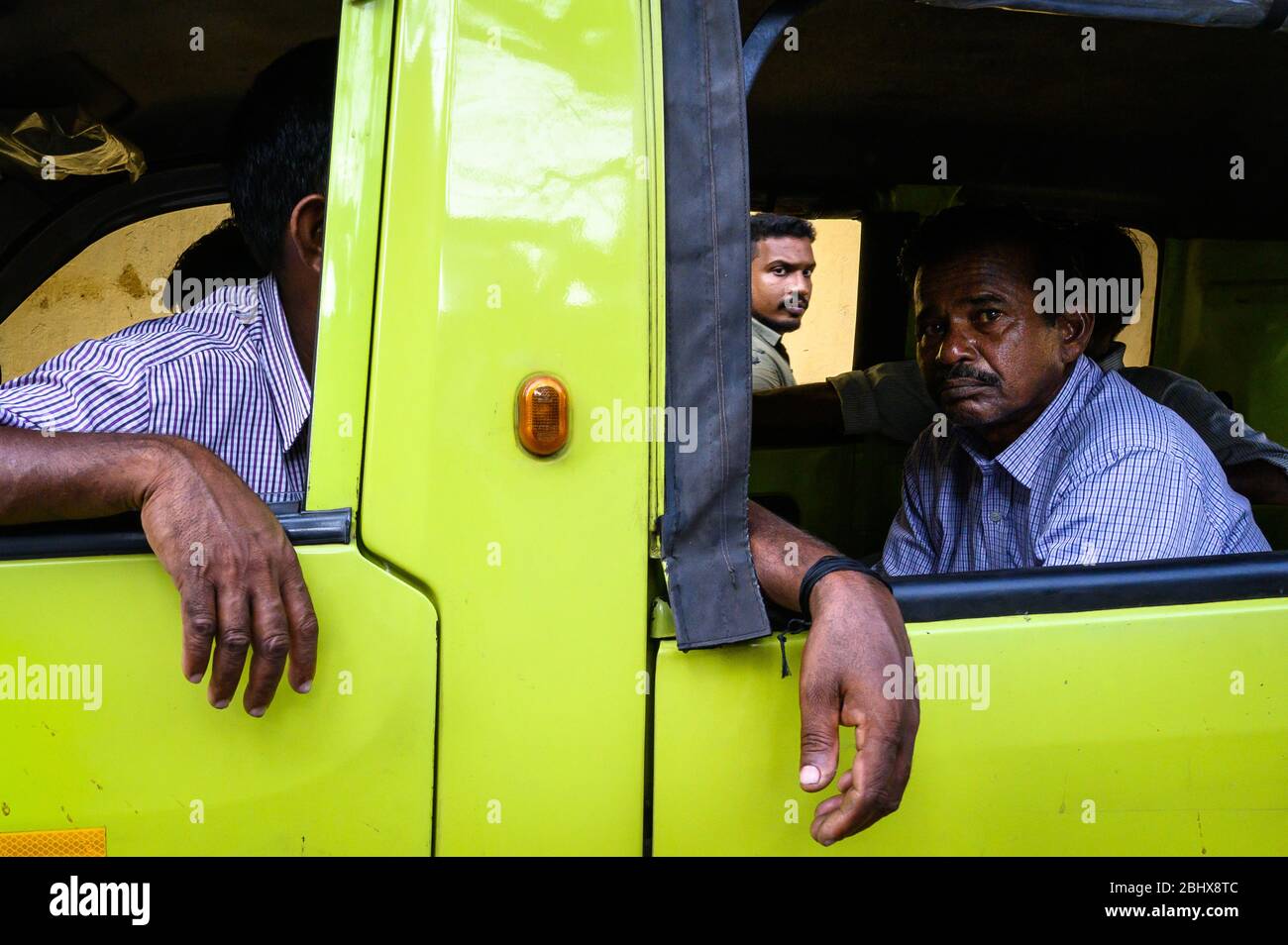 Volti di uomini indiani come visto attraverso la finestra di un furgone, Kochi, India Foto Stock