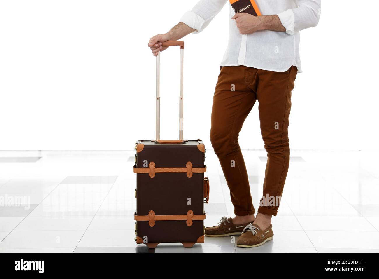 Uomo che tiene valigia in aeroporto Foto Stock