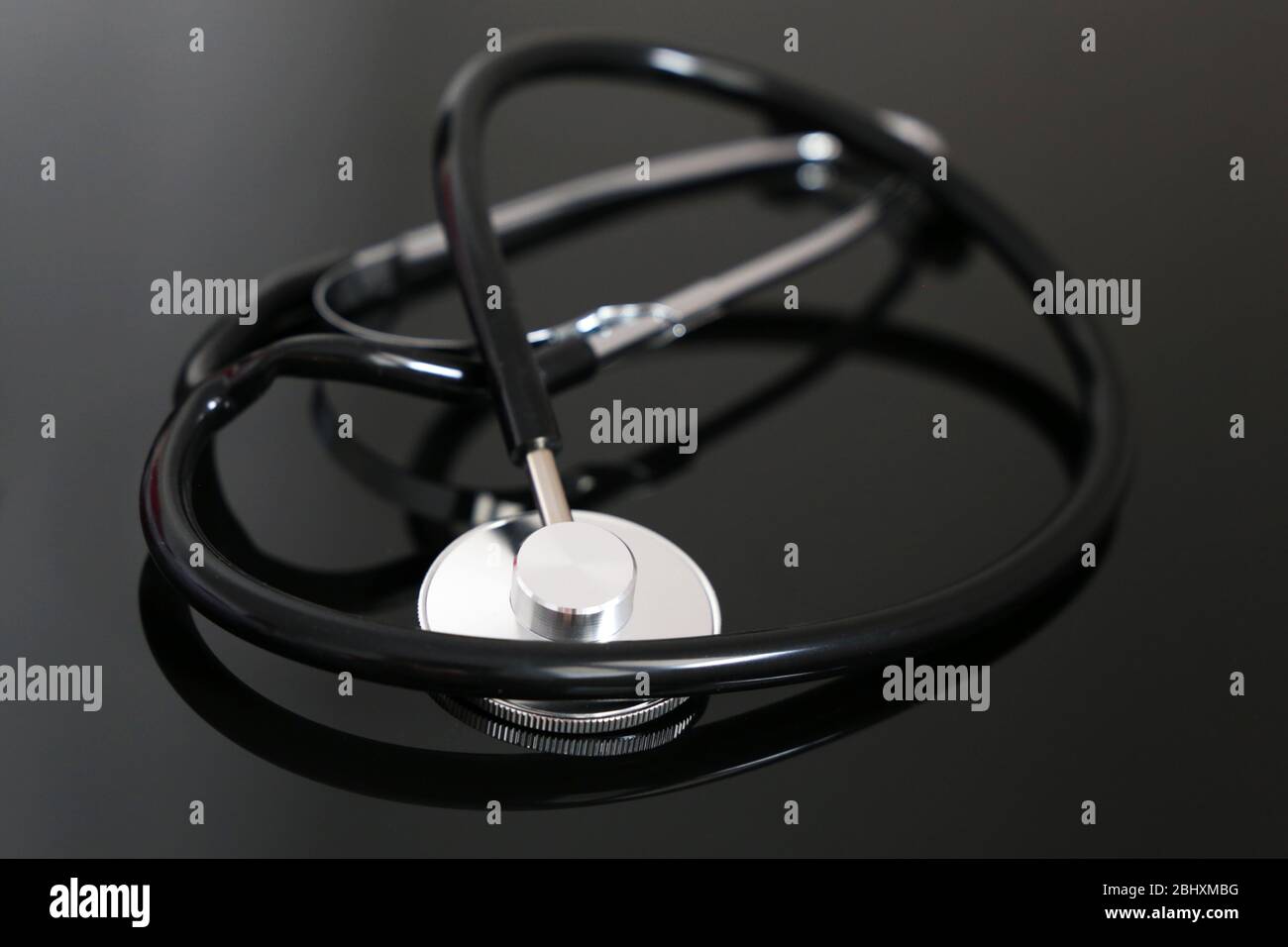 Stetoscopio su tavolo di vetro scuro. Concetto di diagnosi e assistenza sanitaria Foto Stock