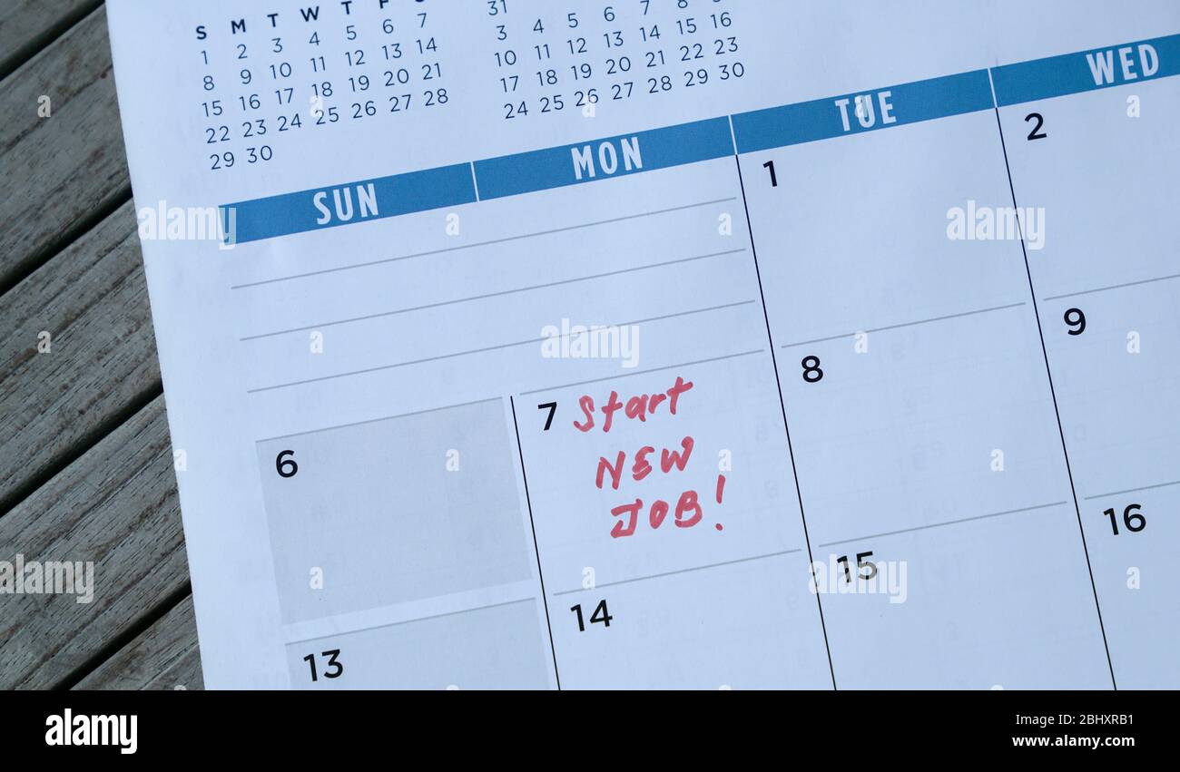Avviare nuove parole di lavoro scritte sul calendario della tabella con un indicatore rosso. Concetto di occupazione o di carriera. Foto Stock