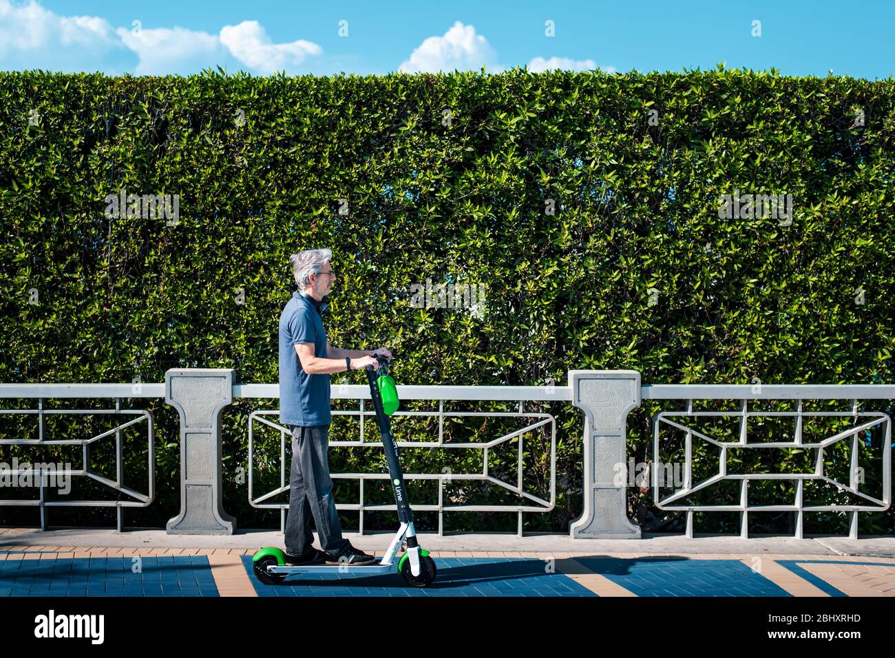 Senior che utilizzano scooter elettrico per il trasporto in un ambiente urbano moderno. Stile di vita sano e di alto livello all'aperto Foto Stock