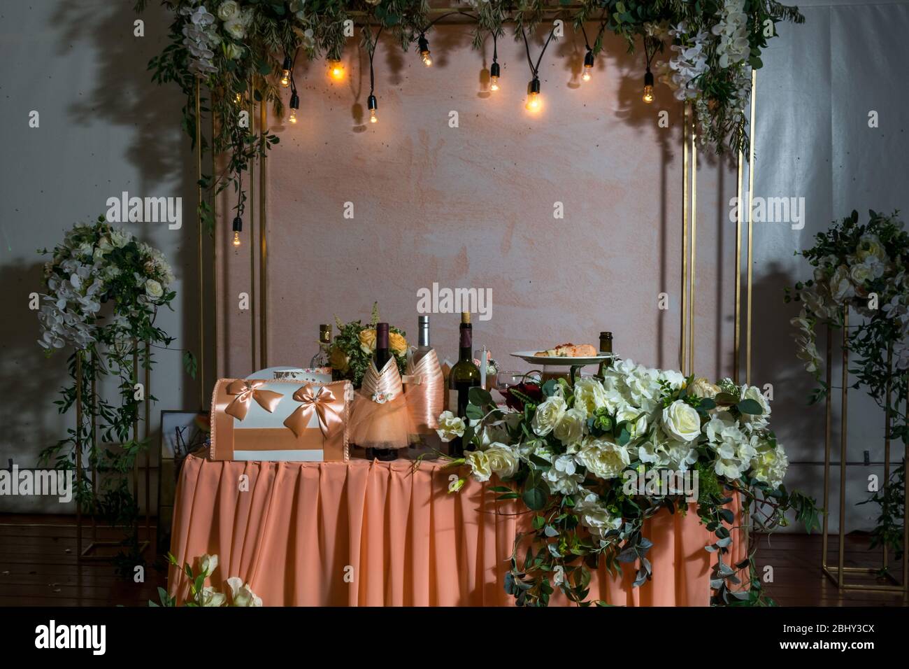 tavolo della sposa e dello sposo splendidamente decorato in colori pesca. decorazioni per matrimoni. crepuscolo Foto Stock