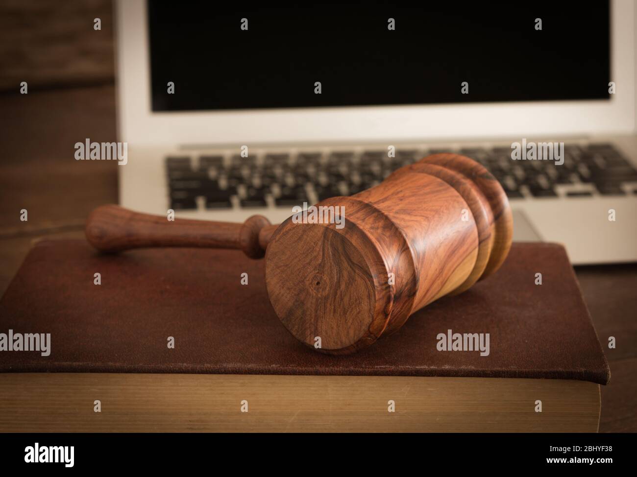 Giudice di legno gavel su libro di legge con computer portatile in background. Concetto di legge informatica o legge su internet. Foto Stock