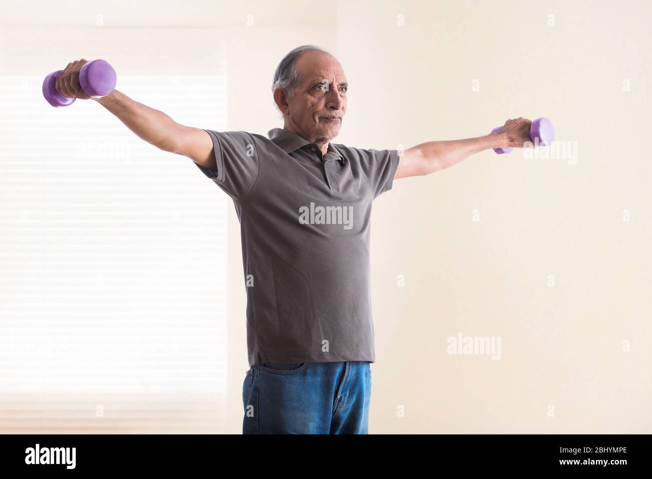 Uomo anziano che fa esercizi con pesi. (Salute e fitness) Foto Stock