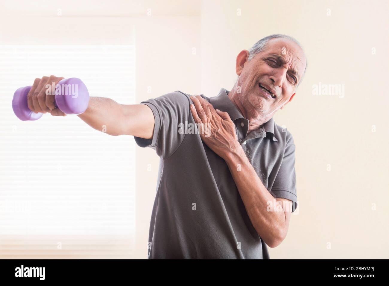 Uomo anziano che fa esercizi con pesi. (Salute e fitness) Foto Stock