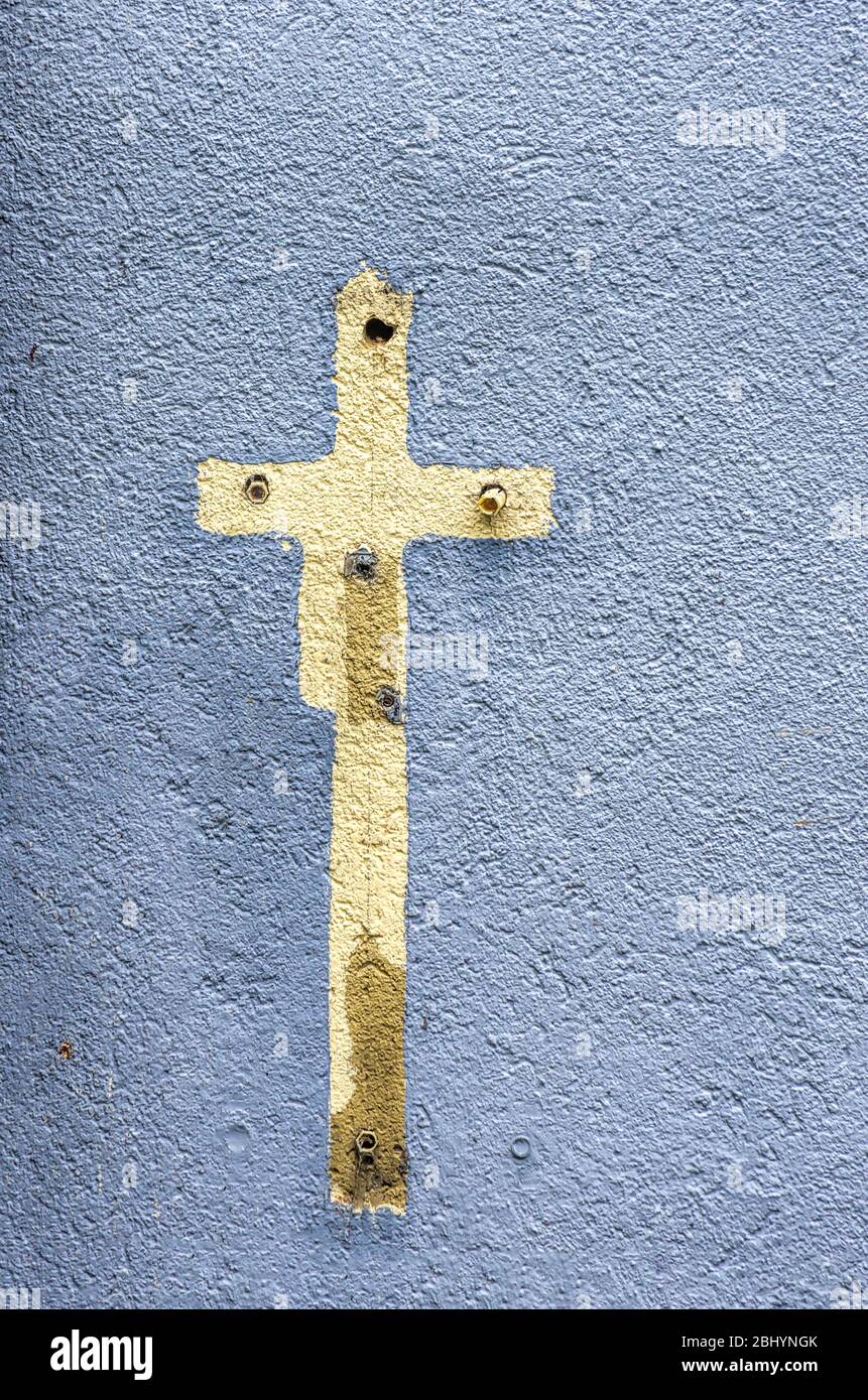 Impronta di un segno a croce circondato di colore su una parete della casa piena di vecchi tasselli di espansione. Foto Stock