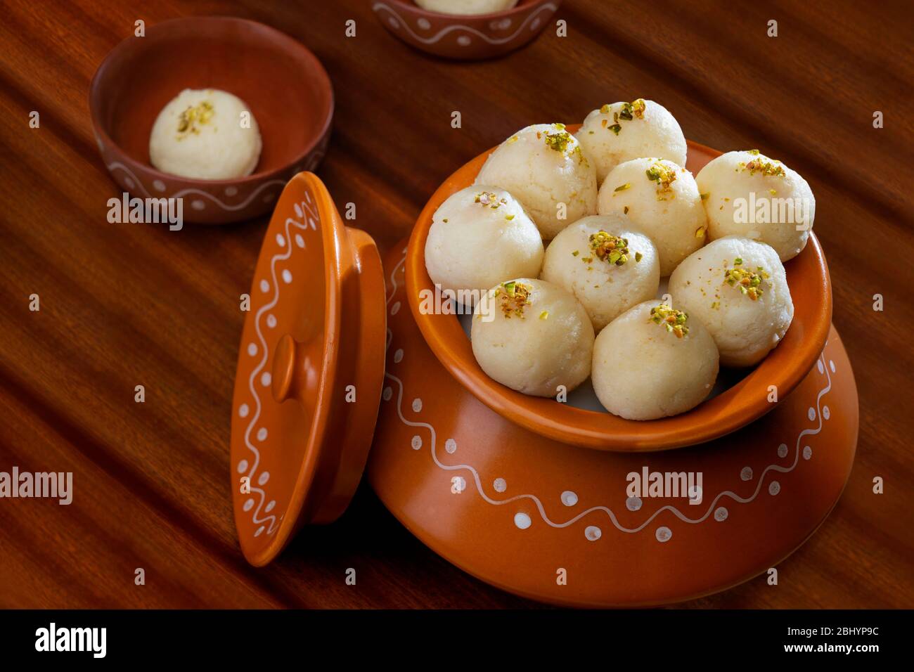 Rasgullas bianco conservato in un handi con pistacchi spruzzati. Foto Stock